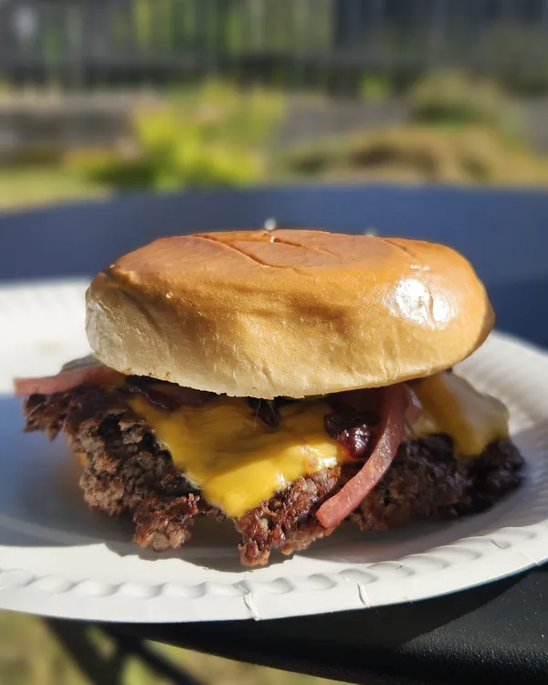 Smash burger z serem cheddar, ogórkiem konserwowym oraz marynowaną cebulą