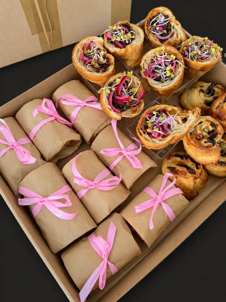 Box na baby shower: wrapy z różowymi wstążkami, croissanty z wołowiną BBQ i ślimaki francuskie