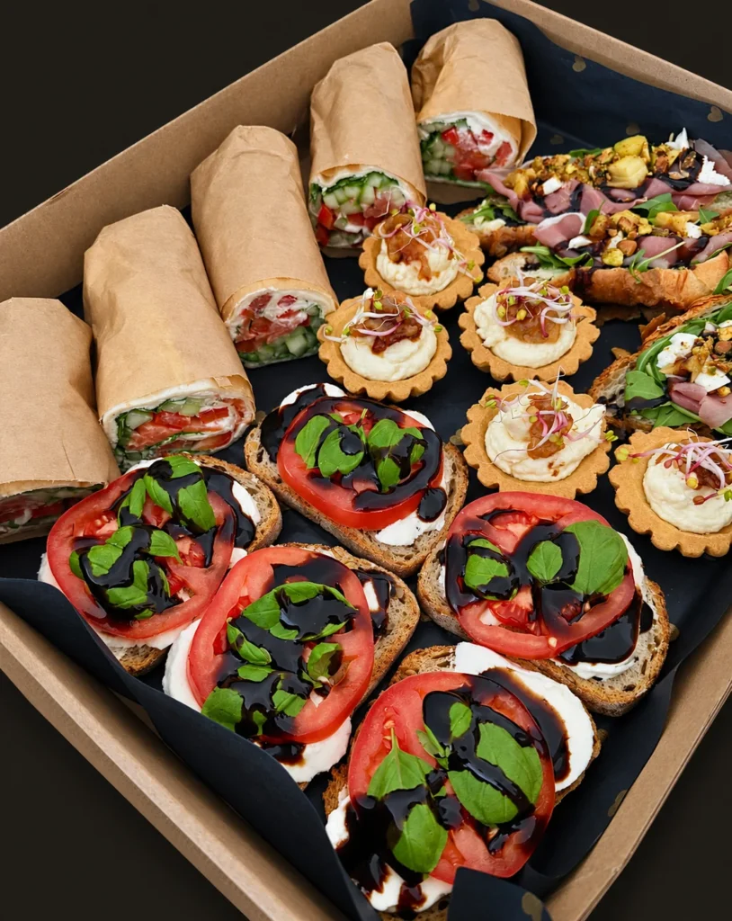 Box premium mix: wrapy z łososiem, kanapeczki z mozzarellą i pomidorem, babeczki z serem pleśniowym, croissanty z szynką parmeńską i mango
